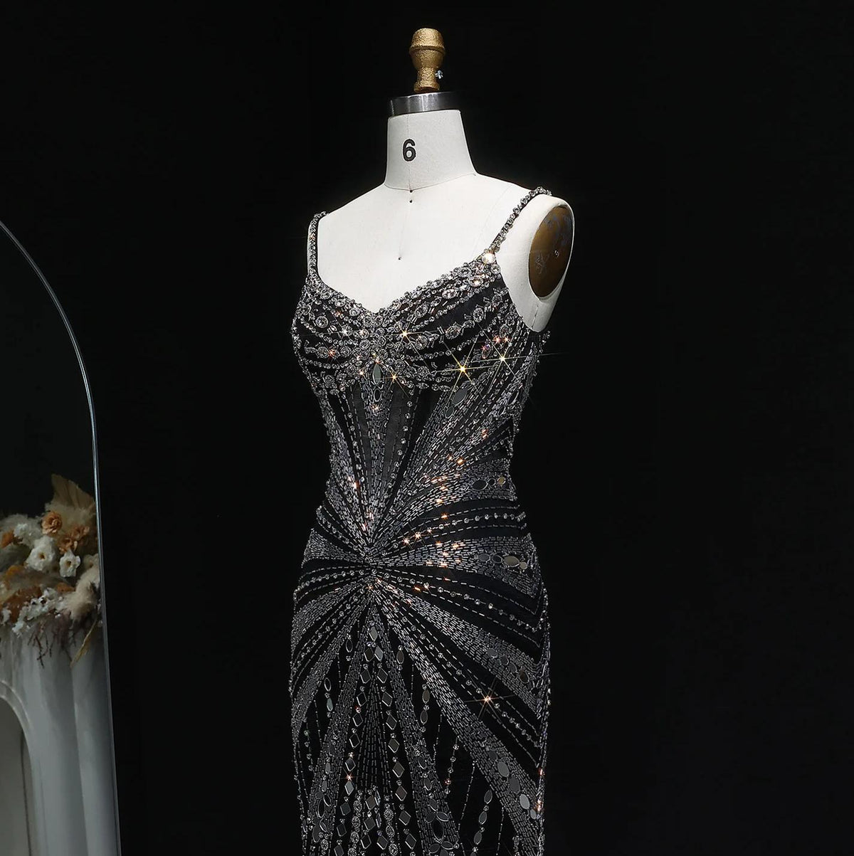 Black satin evening gown with intricate silver beadwork, crystal embellishments, spaghetti straps, and a fitted silhouette.