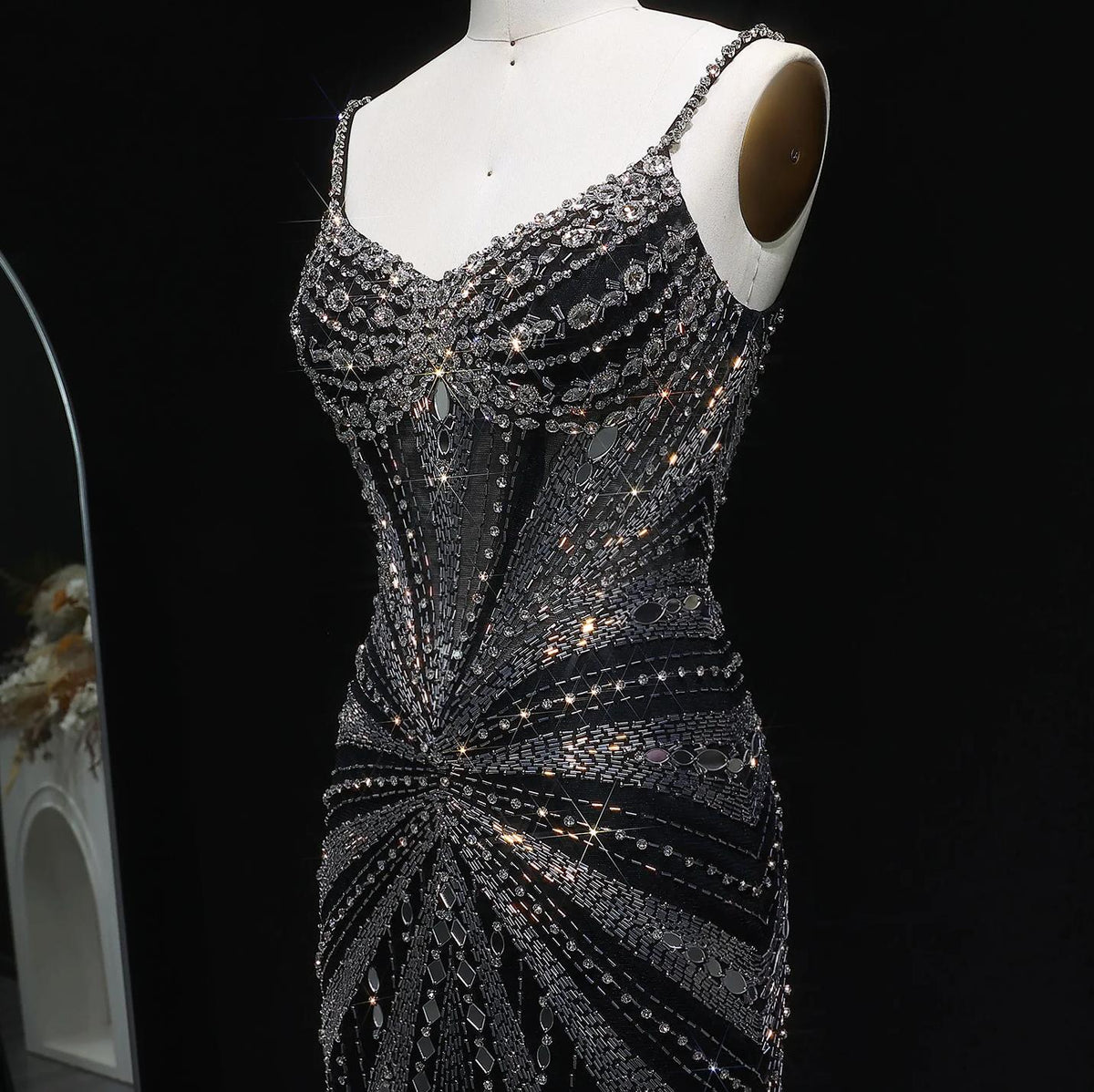 Black satin evening gown with intricate silver crystal beading, spaghetti straps, and a sheer corset-style bodice.