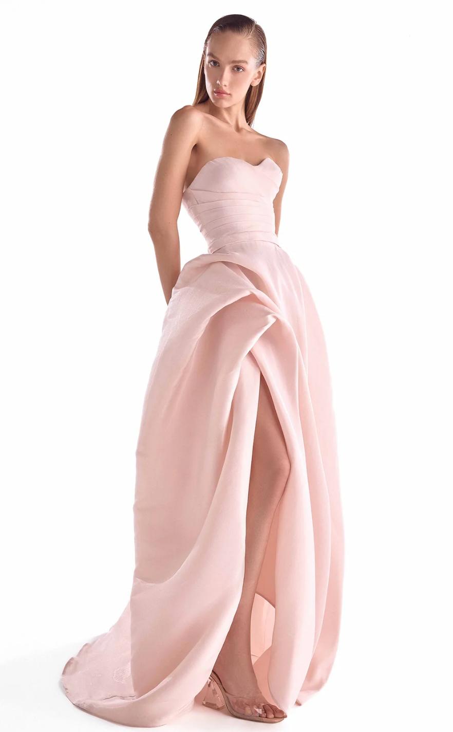 Salmon pink strapless organza gown with a draped bodice, full layered skirt, and a high leg slit.