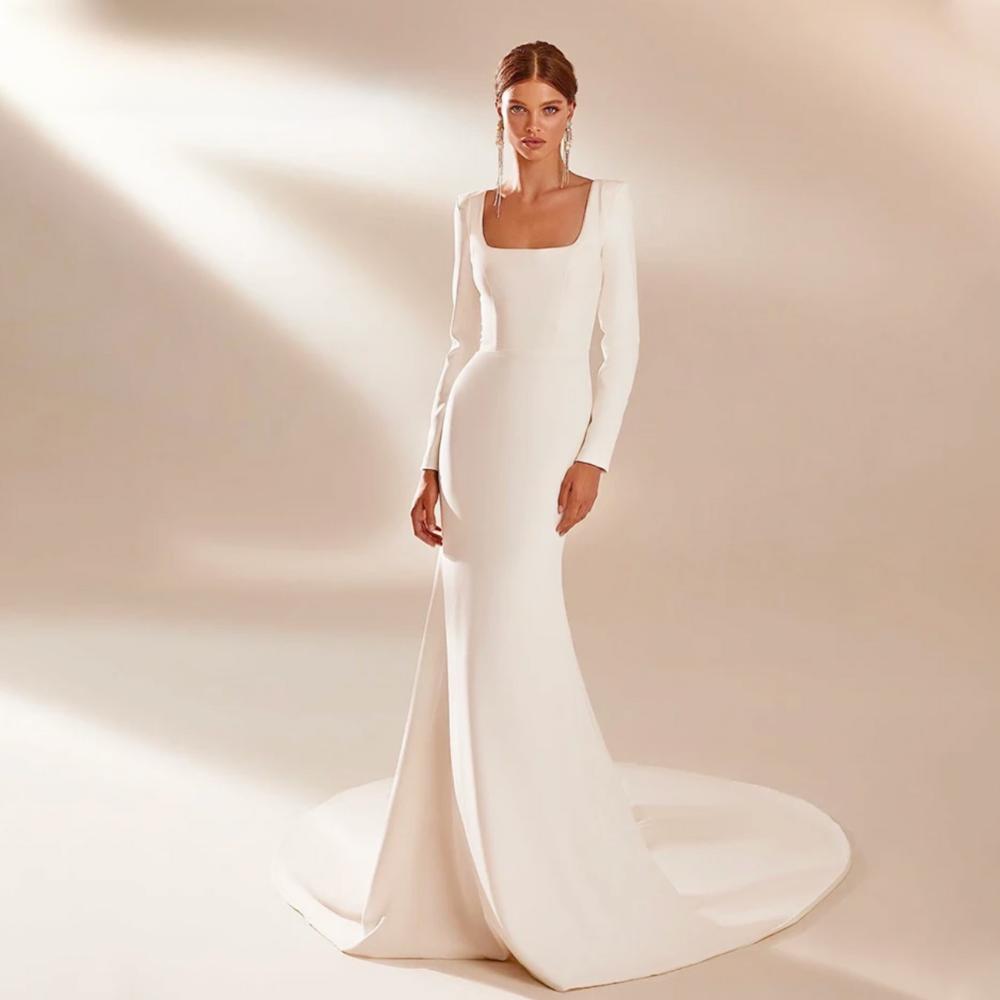 White satin mermaid gown with long sleeves, square neckline, and a sweeping court train.