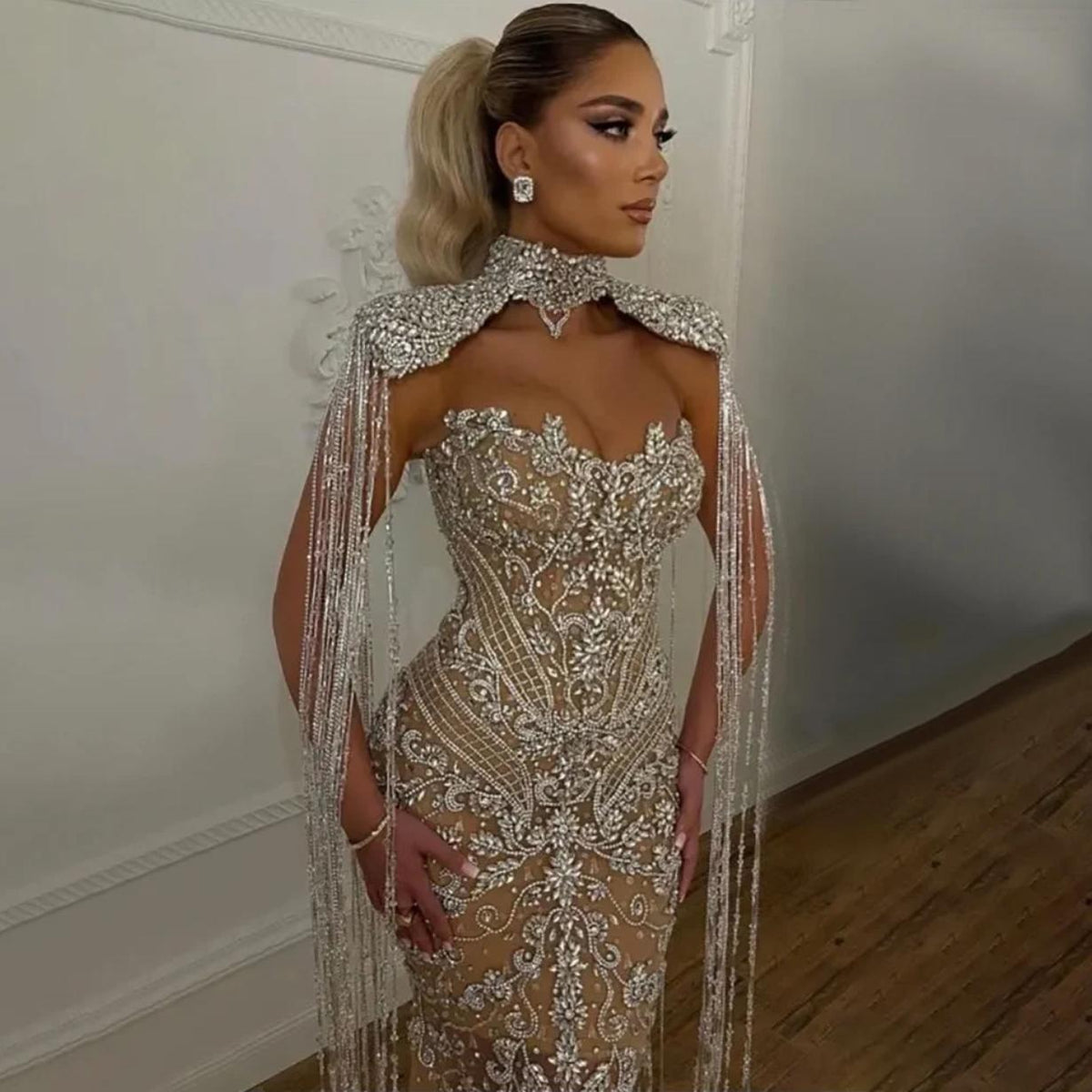 Beaded mermaid wedding gown with crystal embroidery, shimmering sequins, and dramatic hanging silver tassels.