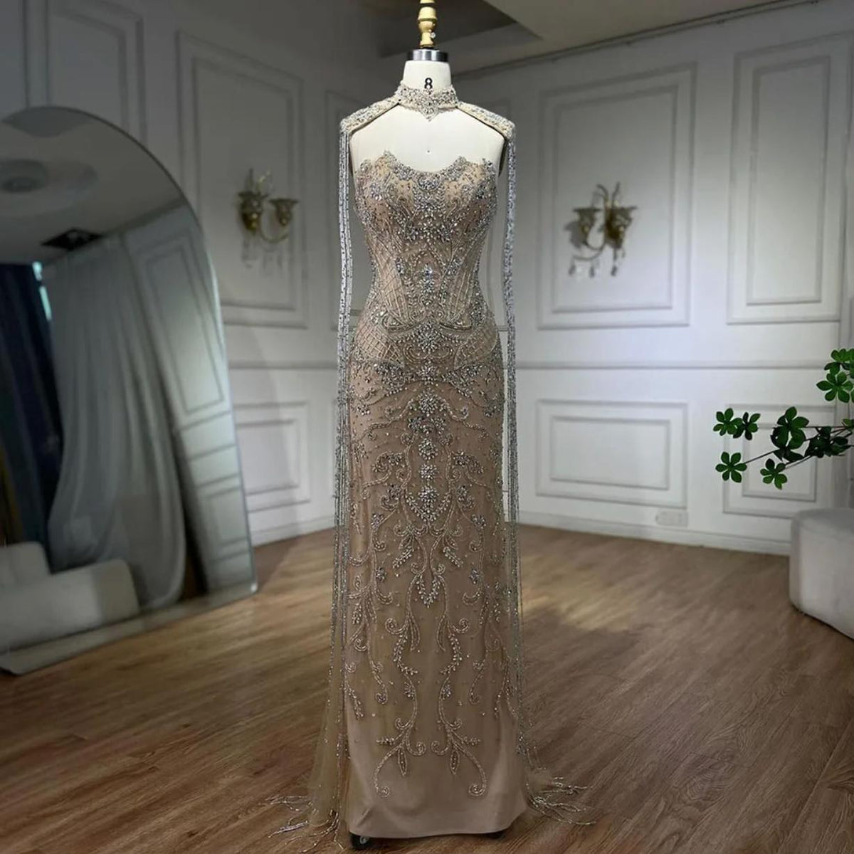 Beaded mermaid wedding gown with shimmering crystals, sequins, and dramatic tassels on a mannequin.