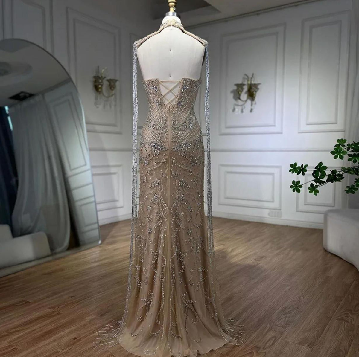 Beaded mermaid wedding gown in nude tulle with crystal embroidery, shimmering sequins, and long decorative tassels.