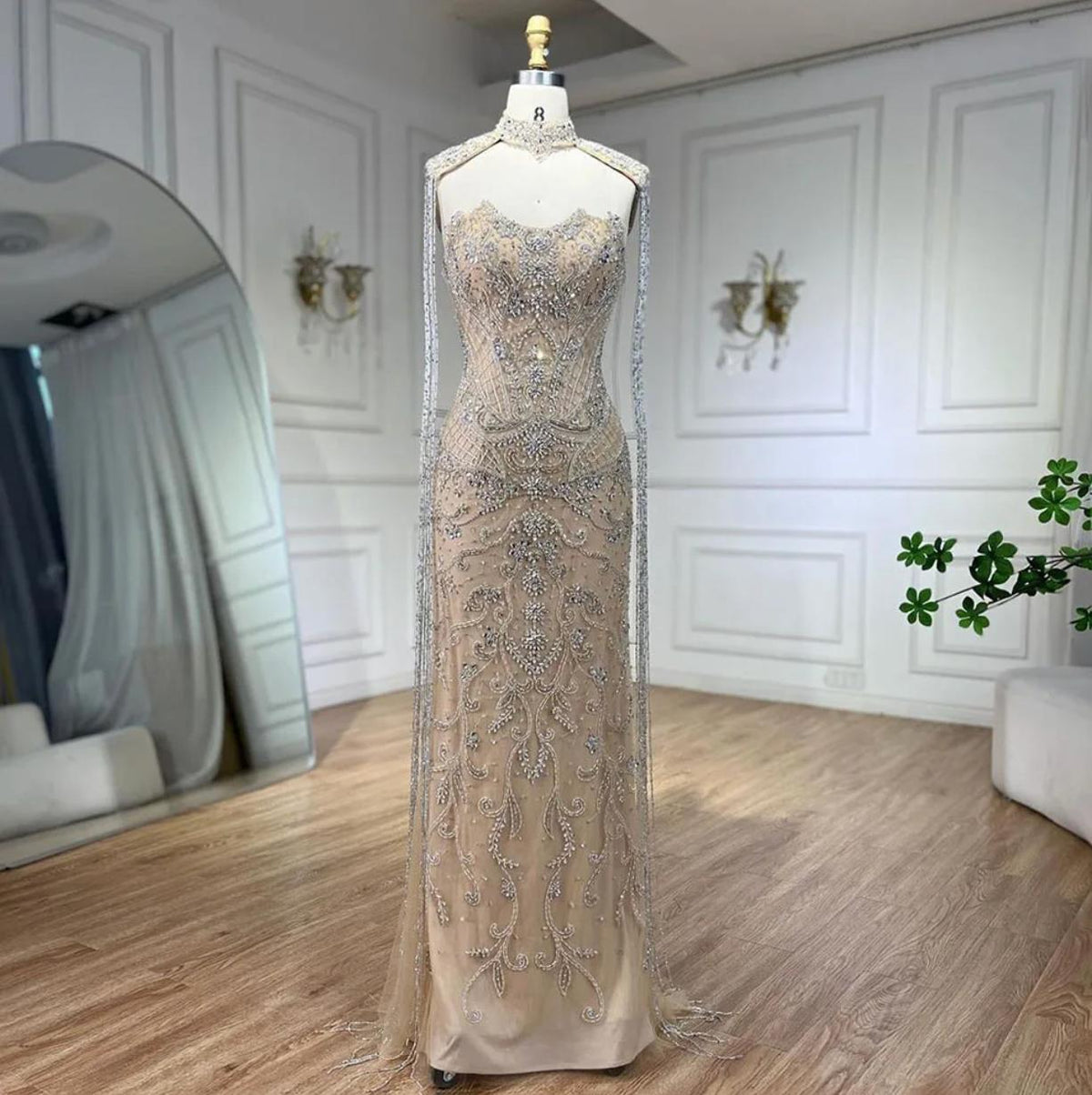 Beaded mermaid wedding gown in nude tulle with crystal embroidery, high neck, and shimmering fringe tassels.