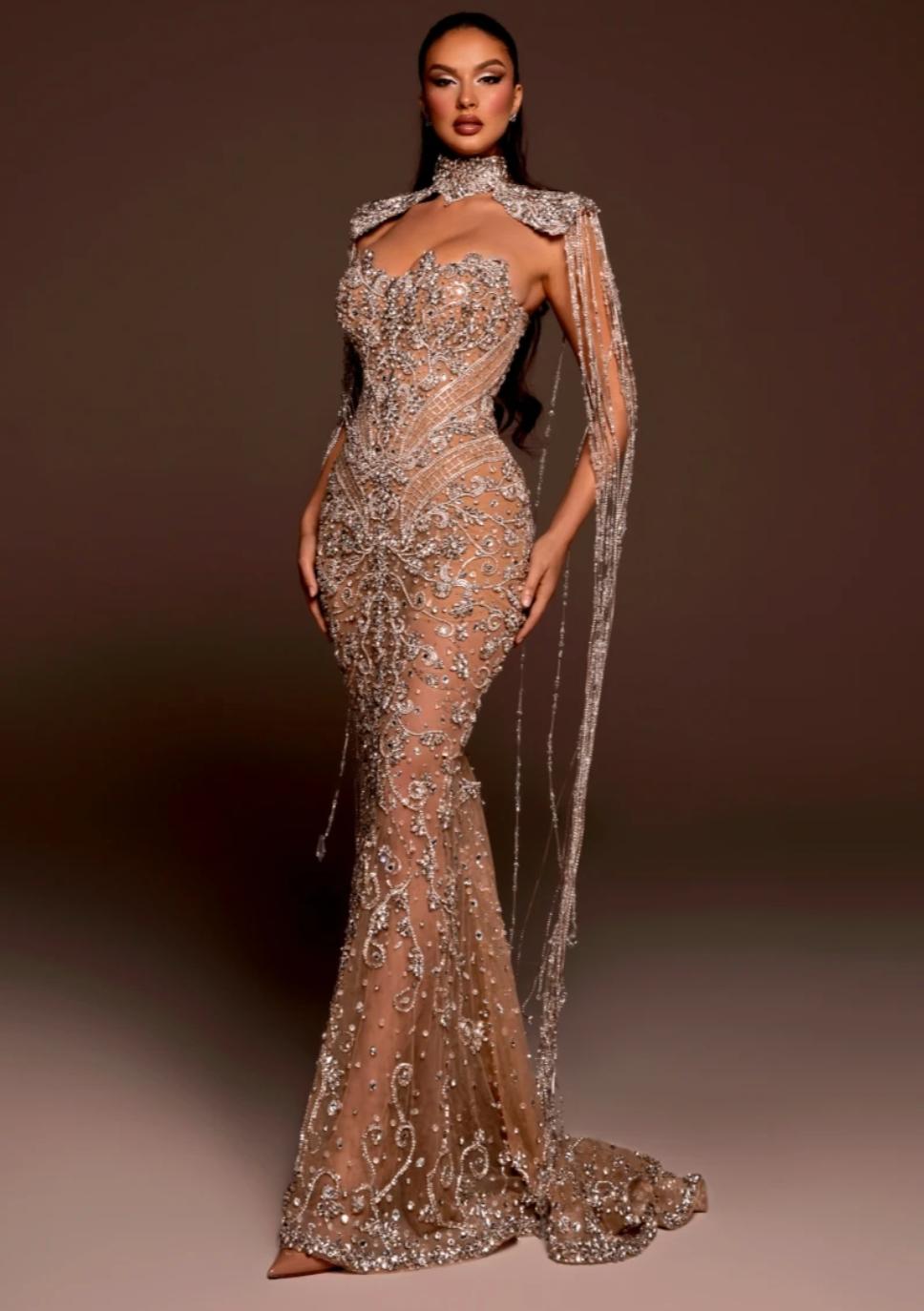 Beaded mermaid bridal gown with shimmering crystals, sequins, and dramatic hanging tassels on a sheer tulle base.
