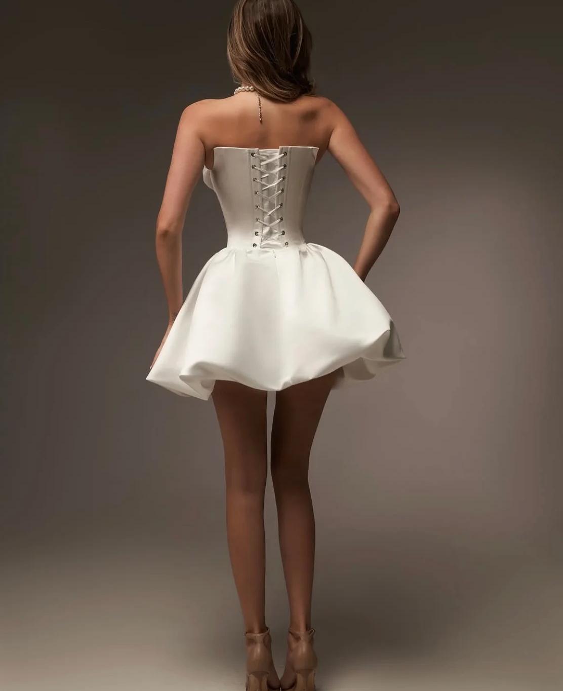 Strapless white satin mini wedding dress with an A-line silhouette and a corset-style lace-up back.