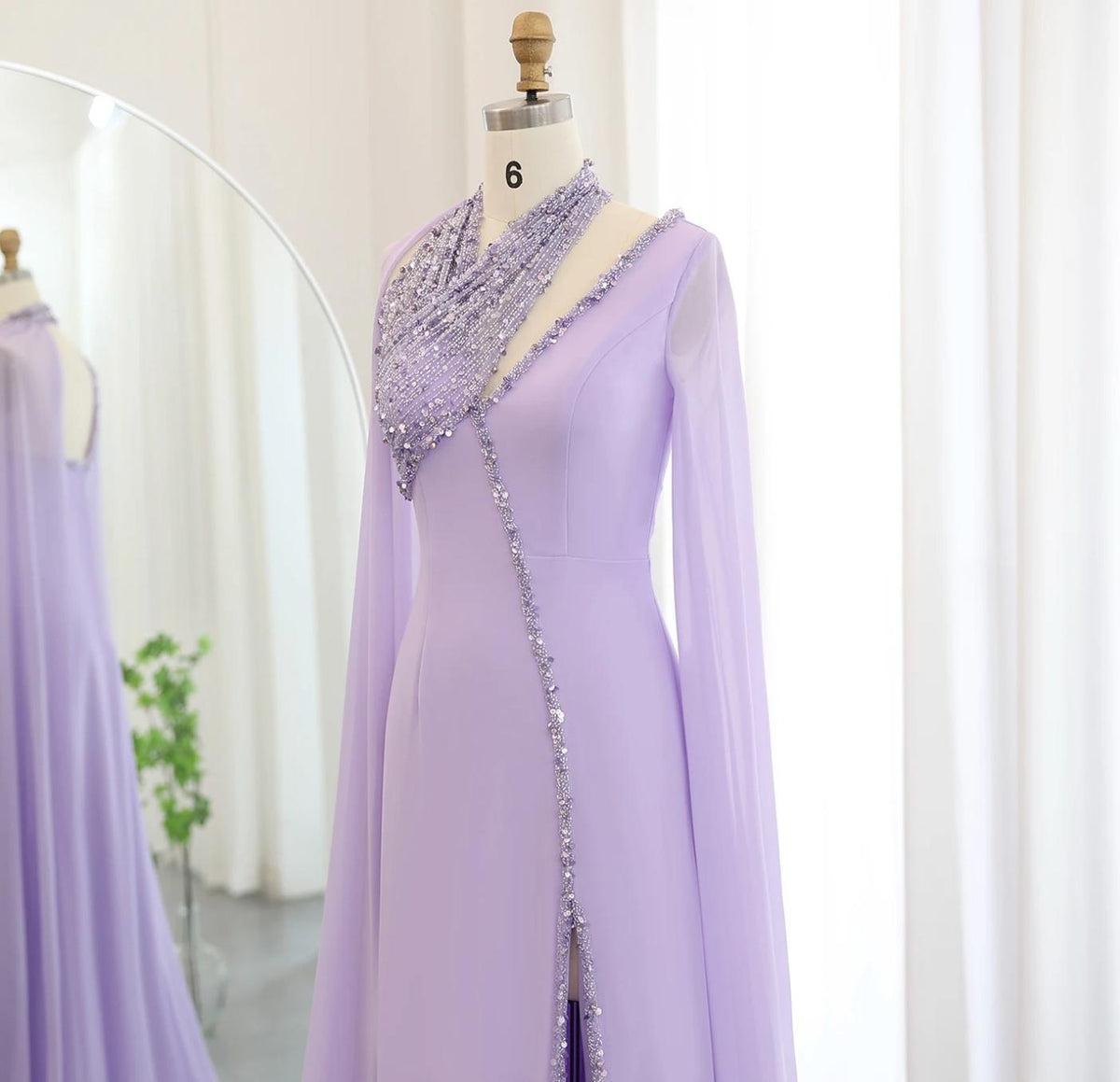 Lavender chiffon Selma gown with beaded halter neckline, cape sleeves, and crystal embellishments on a mannequin.