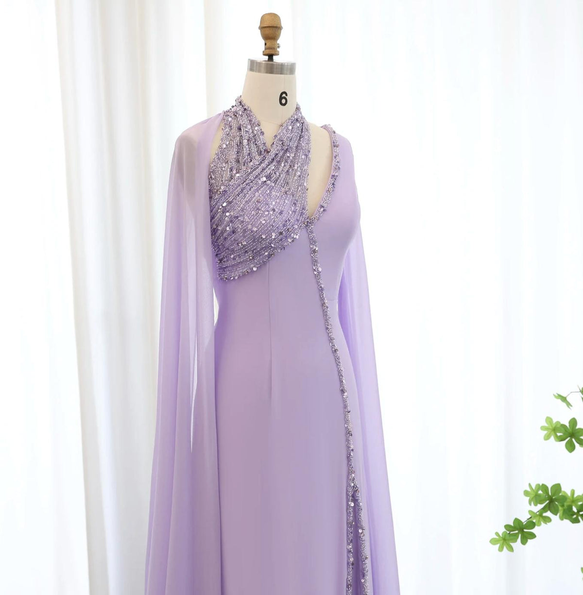 Lavender chiffon Selma gown with a beaded halter neckline, crystal embellishments, and dramatic flowing cape sleeves.