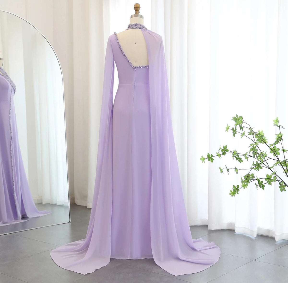 Lavender chiffon Selma gown featuring a beaded halter neckline, open back, and dramatic flowing cape sleeves.