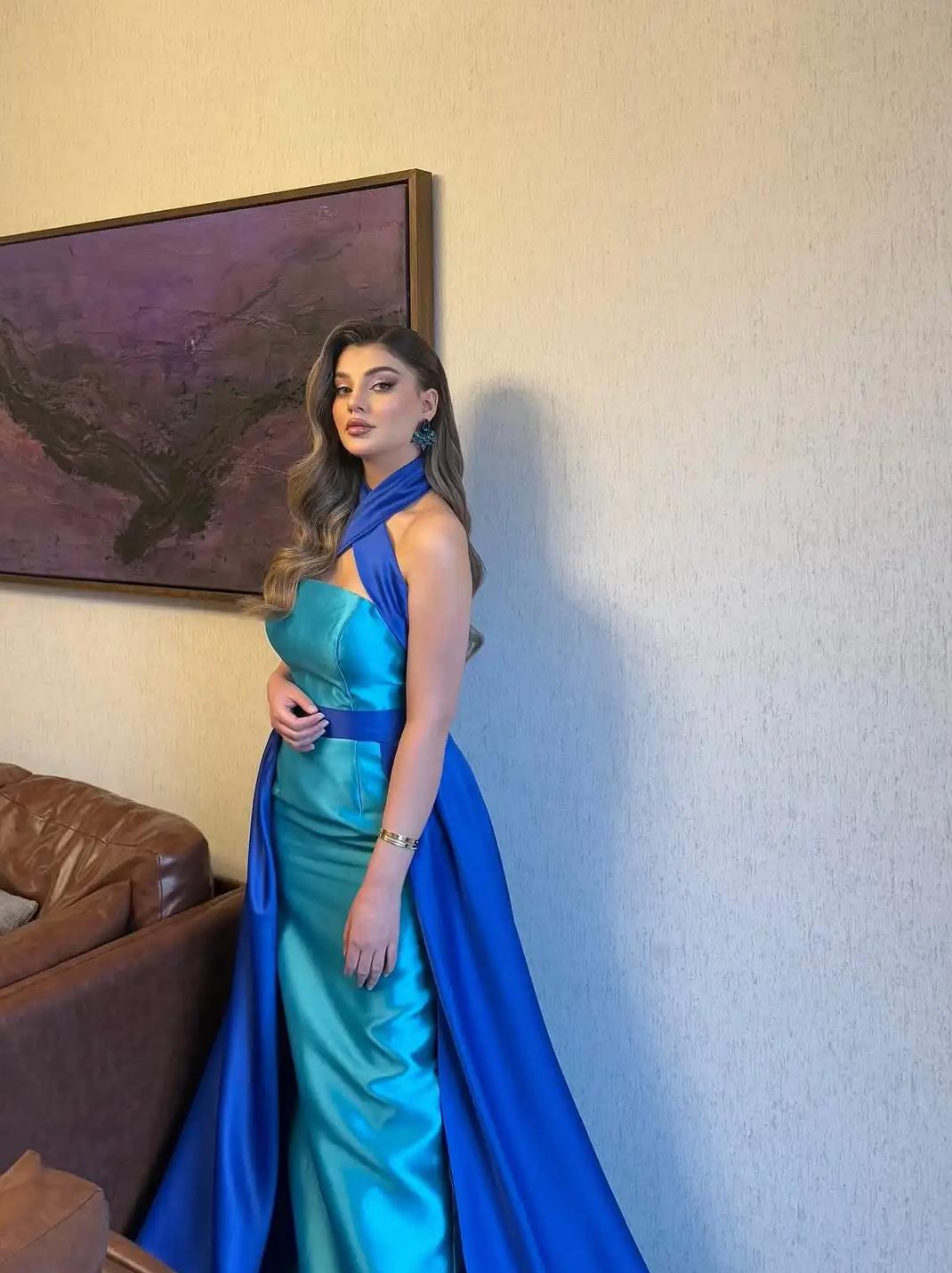 Sleeveless Serene Gown featuring a turquoise satin halter top and a bold royal blue floor-length A-line overskirt.