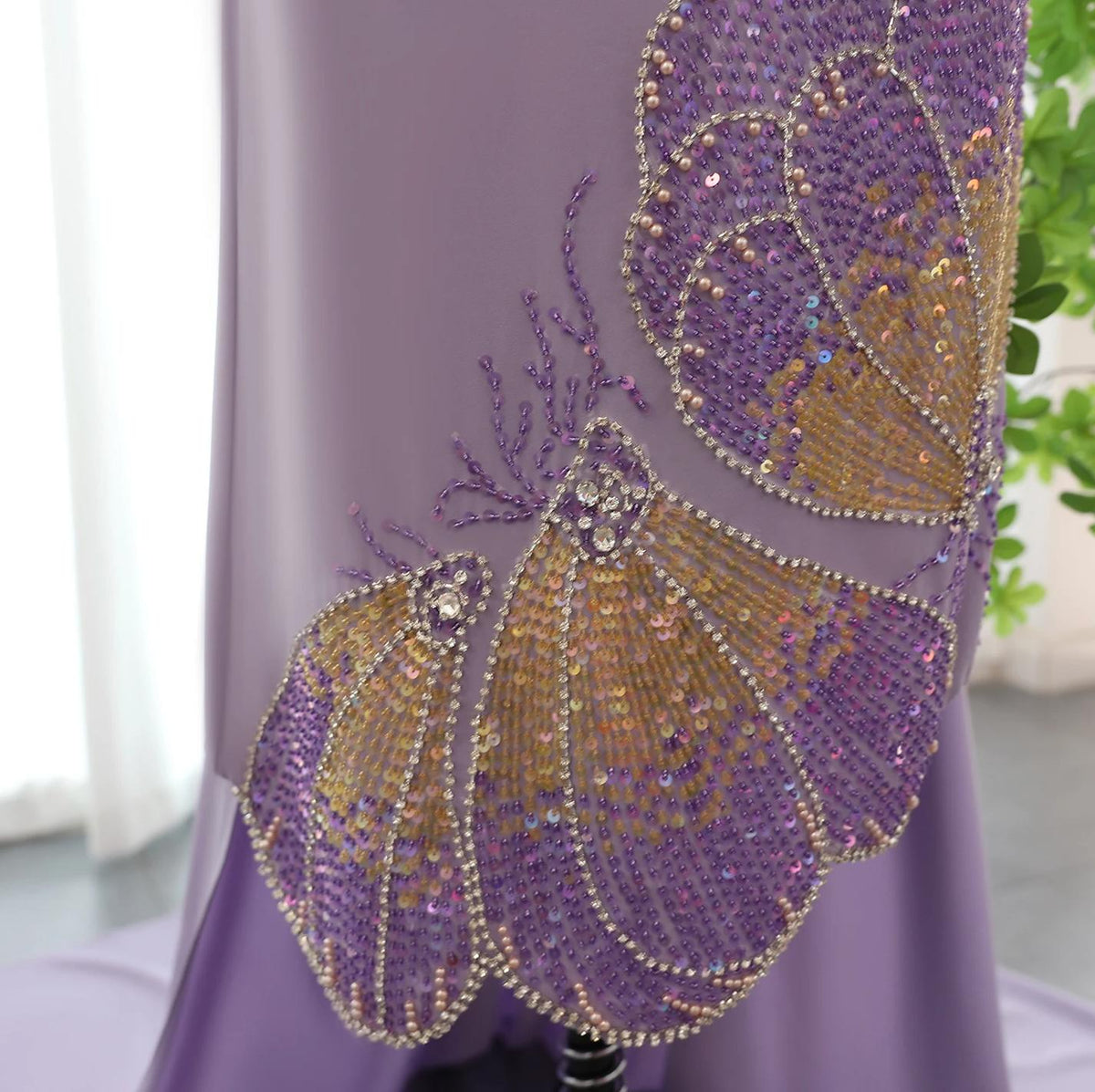 Lavender jersey evening gown featuring intricate butterfly-inspired beading, crystals, and sequin embellishments.