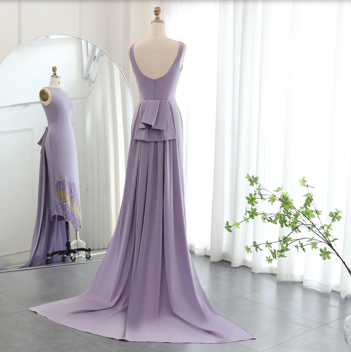 Lavender sleeveless jersey evening gown with a back bow, train, and butterfly-inspired sequin detailing.