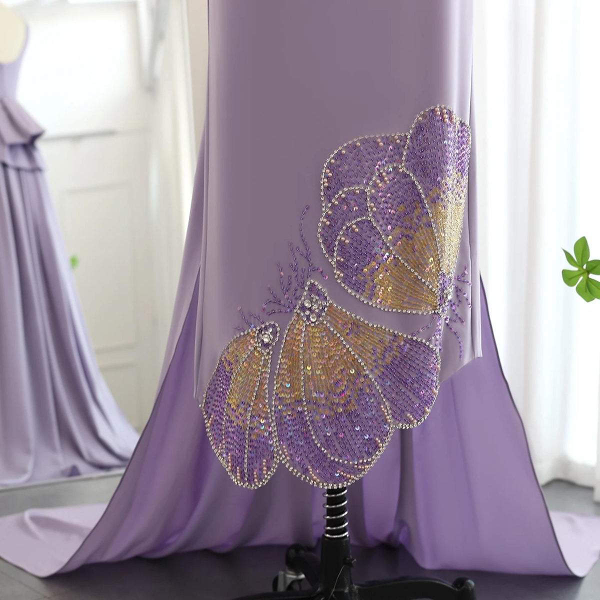 Lavender jersey evening gown featuring intricate butterfly-inspired beading, sequins, and crystal embellishments.