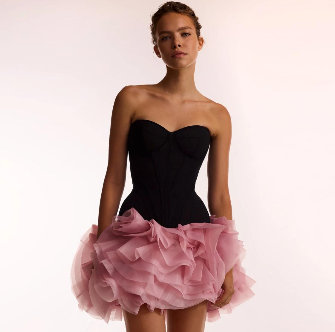 Strapless black corset mini dress with a voluminous pink organza ruffled skirt.