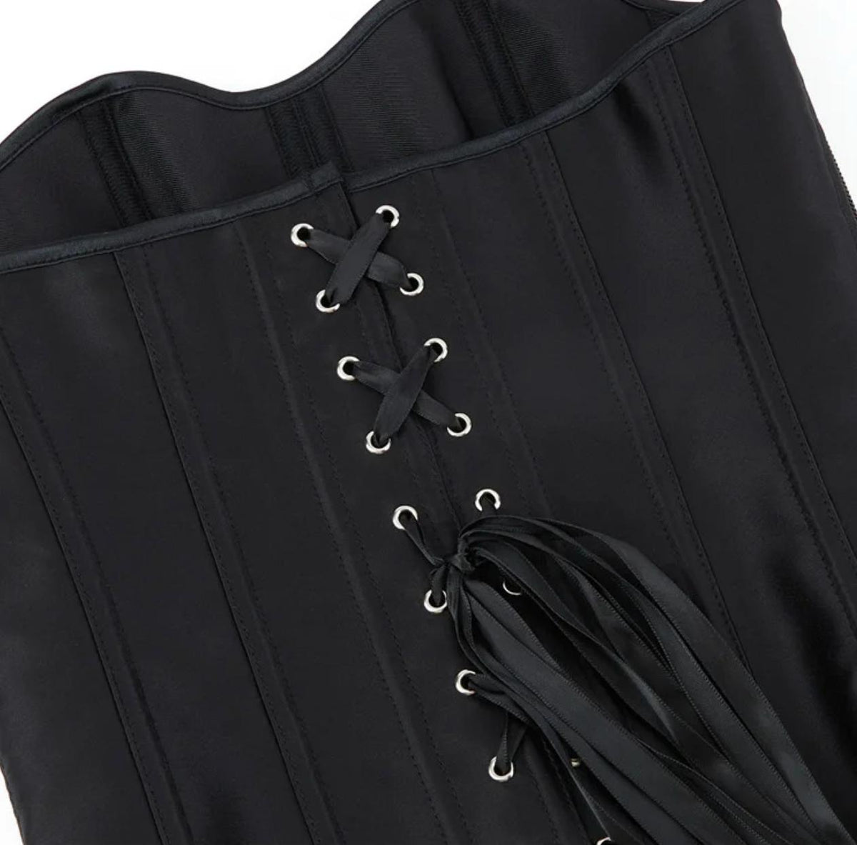 Black satin Soli overbust corset featuring structured boning, silver eyelets, and a crisscross ribbon lace-up back closure.