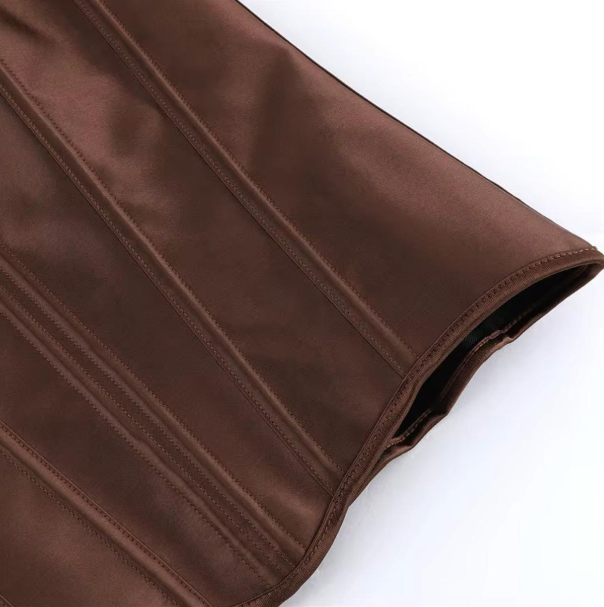 Close-up of a brown satin Soli corset featuring structured boning and a smooth, luxurious finish.