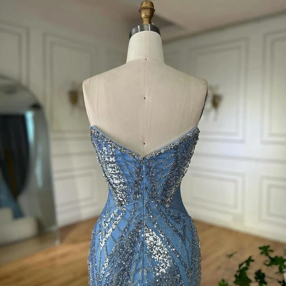 Strapless blue tulle mermaid gown featuring intricate silver sequin and beadwork patterns on a dress form.