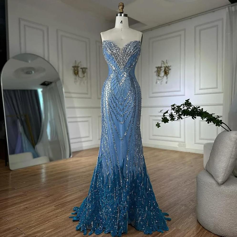 Strapless blue mermaid gown featuring intricate silver beadwork and sequin detailing on tulle, displayed on a mannequin.