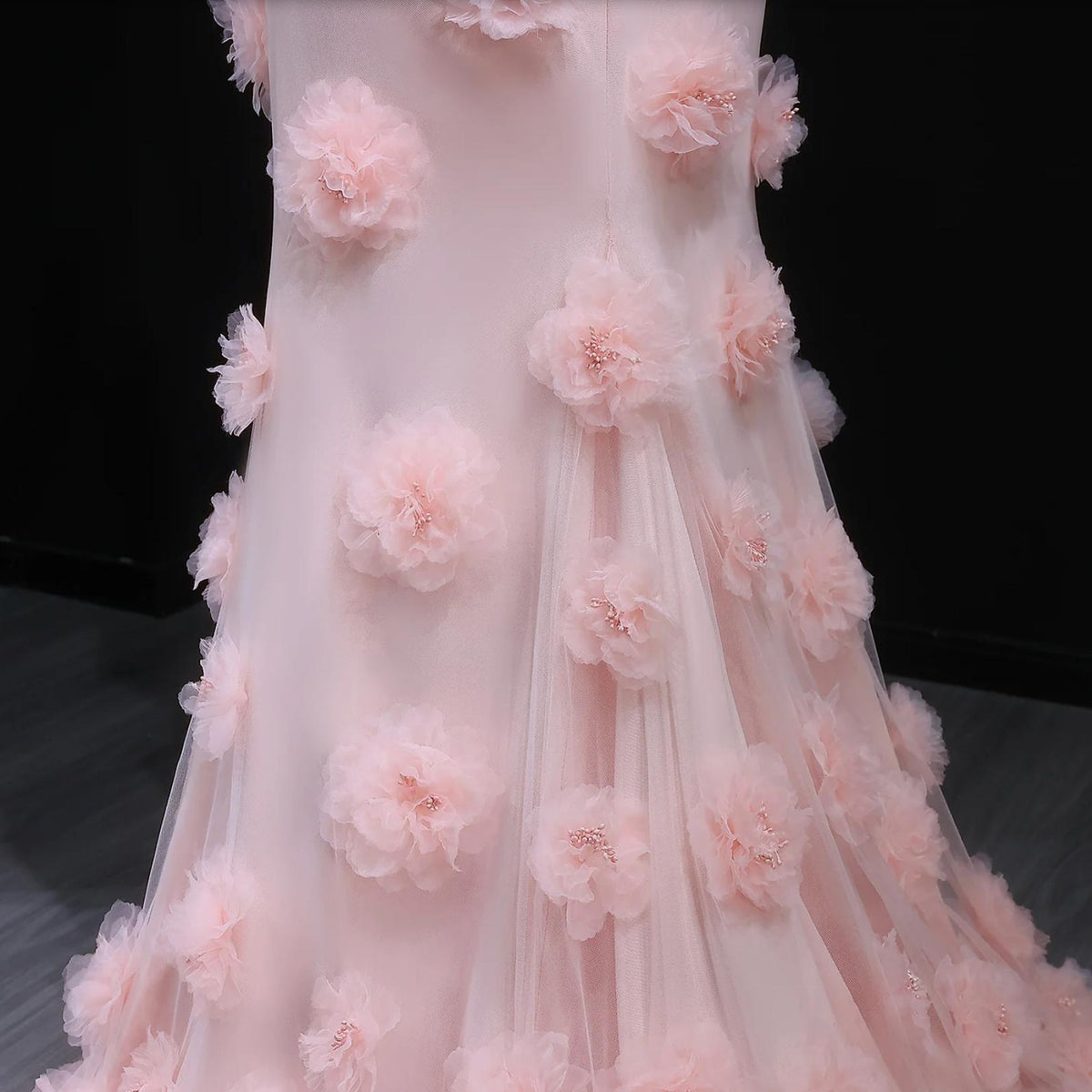 Pink satin mermaid evening gown featuring delicate 3D floral accents and a floor-length silhouette.