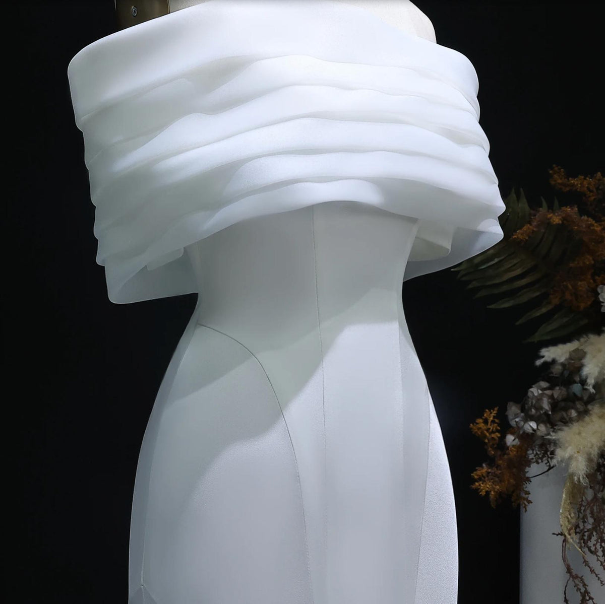 White off-shoulder mermaid evening gown in smooth satin with a layered, pleated bodice design.