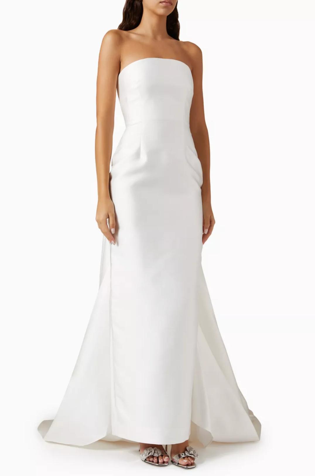 Strapless white satin floor-length gown with a detachable train and fitted silhouette.