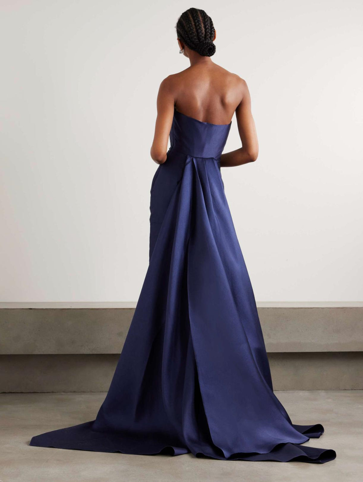 Strapless navy blue satin evening gown with a floor-sweeping detachable demi train and structured twill silhouette.