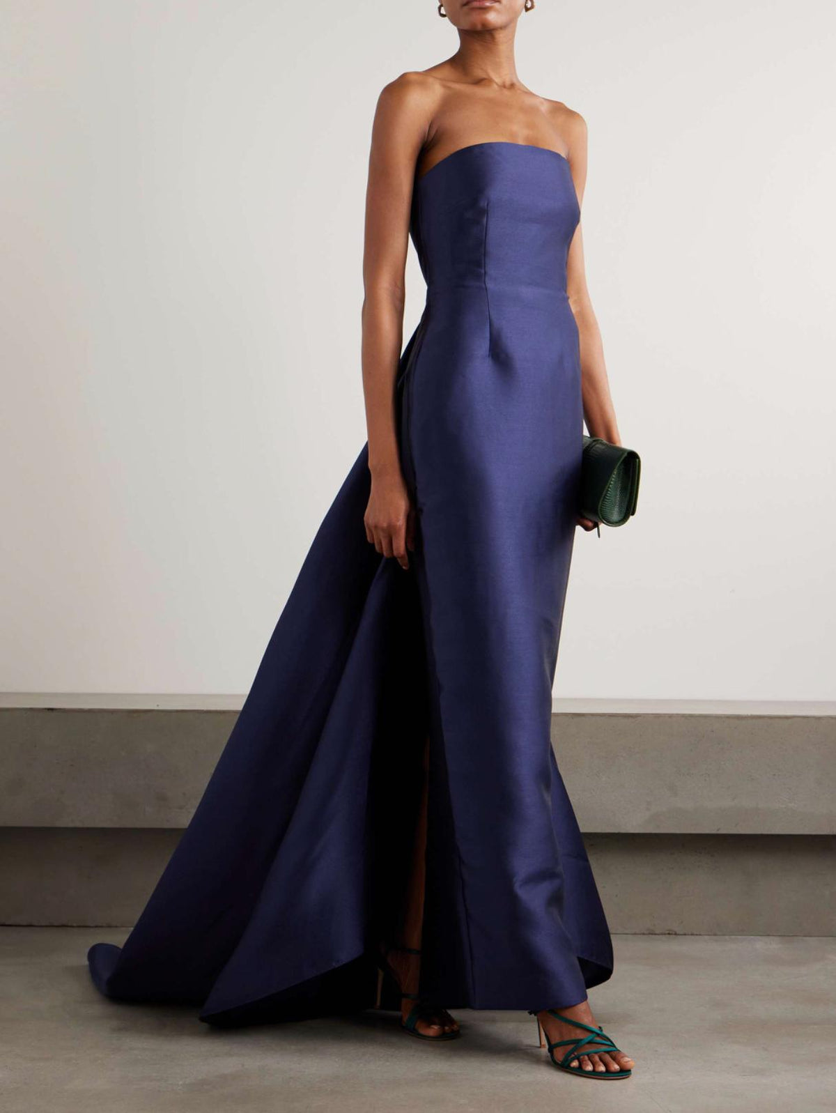 Strapless navy blue satin floor-length gown with a detachable demi train and structured bodice.