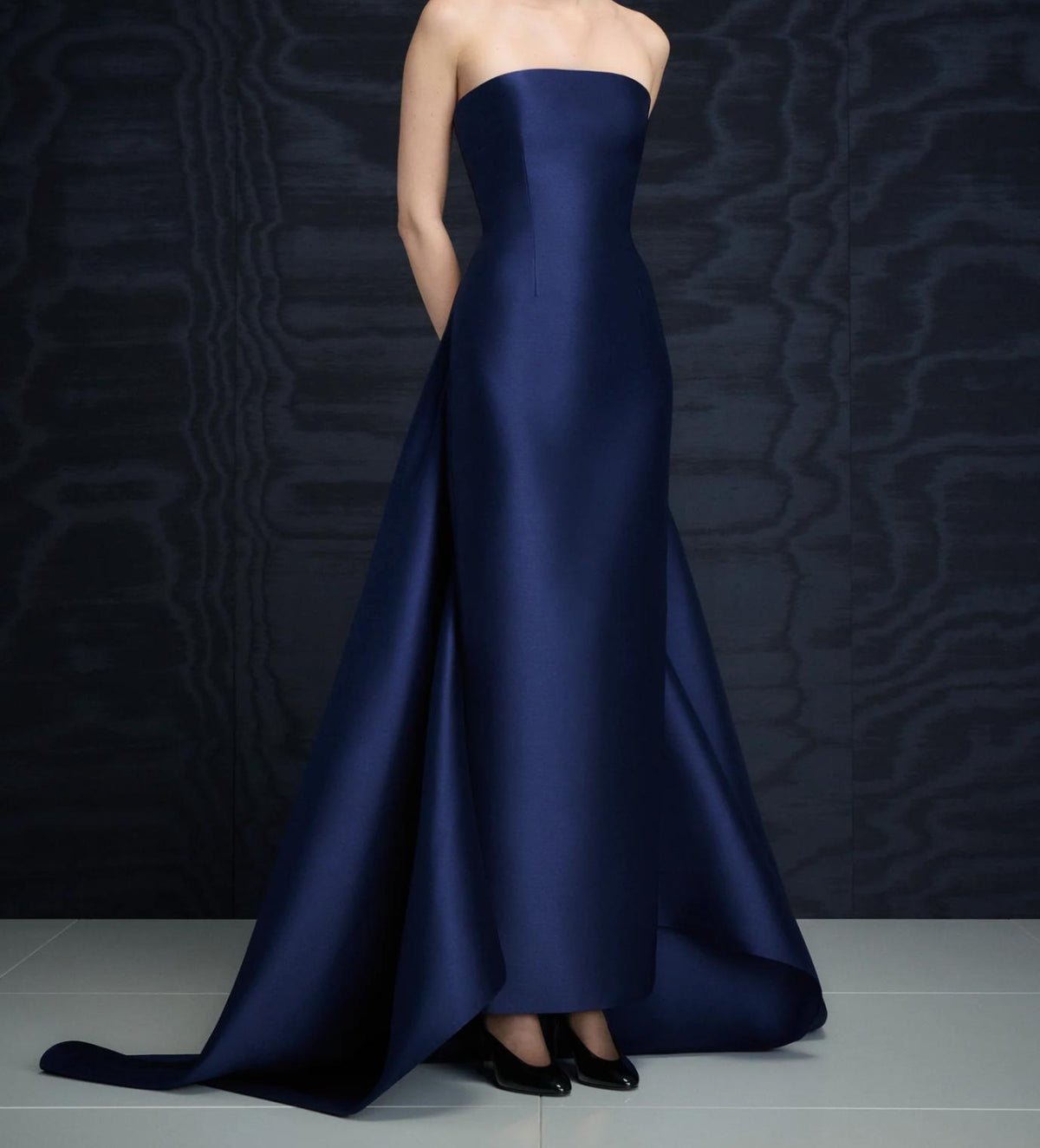 Strapless navy blue satin evening gown with a floor-sweeping detachable train and structured silhouette.
