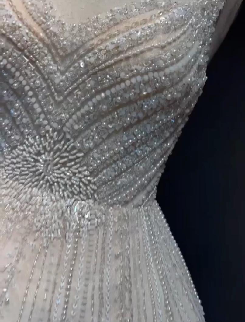Champagne tulle mini dress featuring intricate silver beadwork, sequins, and crystal embellishments with an empire waist.