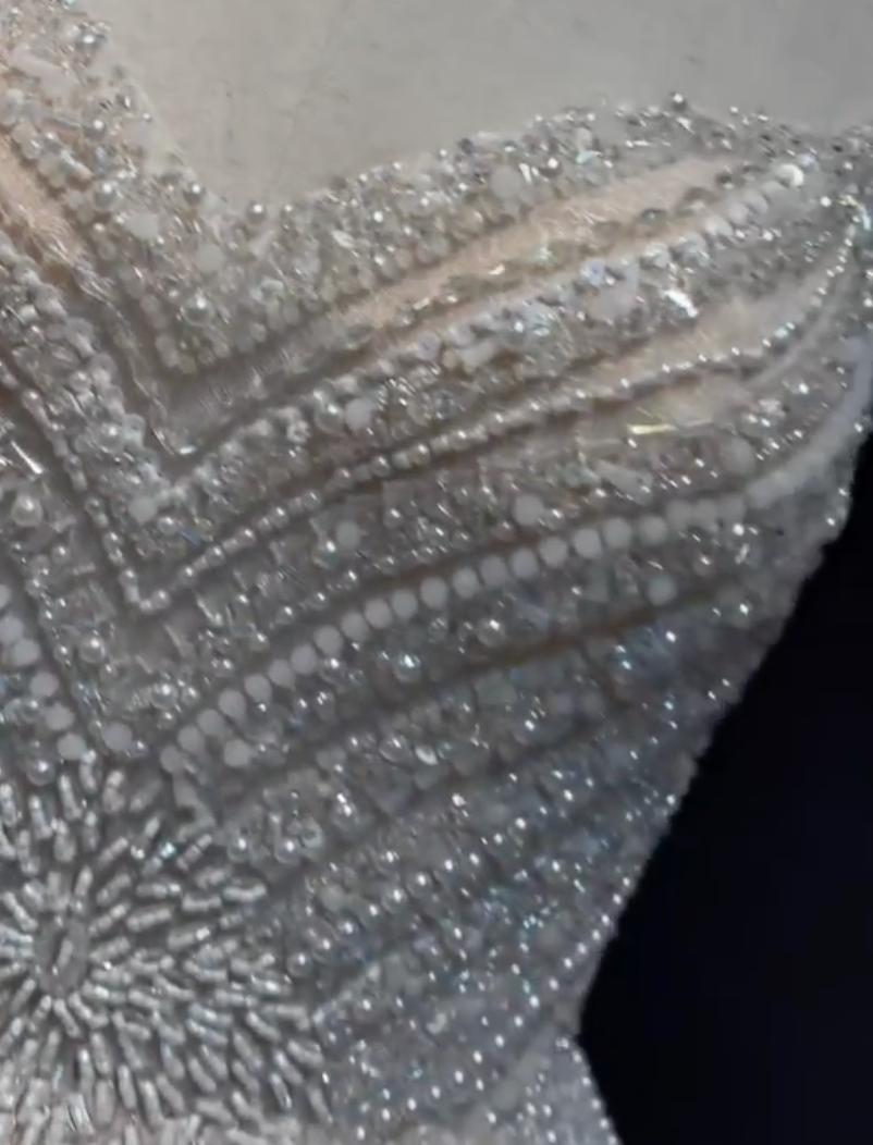 Champagne tulle mini dress featuring intricate heavy beading, sparkling crystals, and sequins in a scoop neckline design.