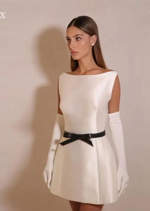 Elegant white satin mini dress with a boat neckline, A-line silhouette, and a black waist bow, styled with long gloves.