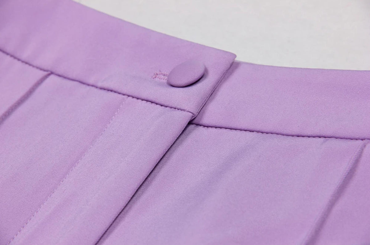 Close-up of lavender Italian satin trousers featuring a tailored waistband, fabric-covered button, and clean stitching.