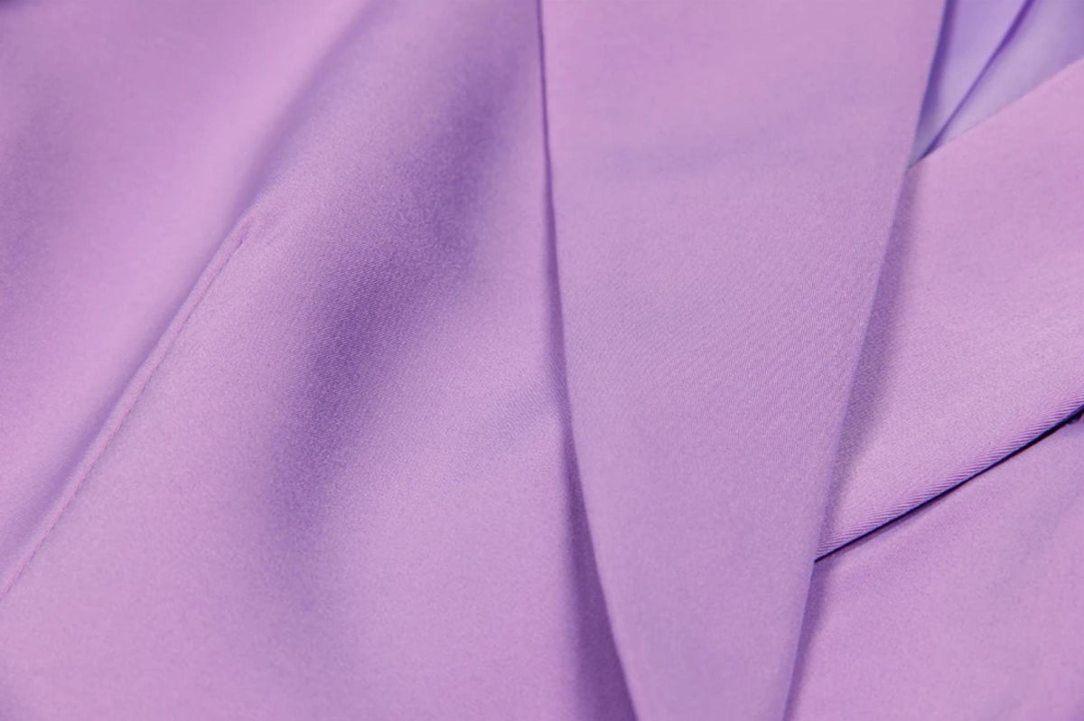 Close-up of The Mulia two-piece suit in lavender Italian satin with sharp double-breasted lapel detailing.