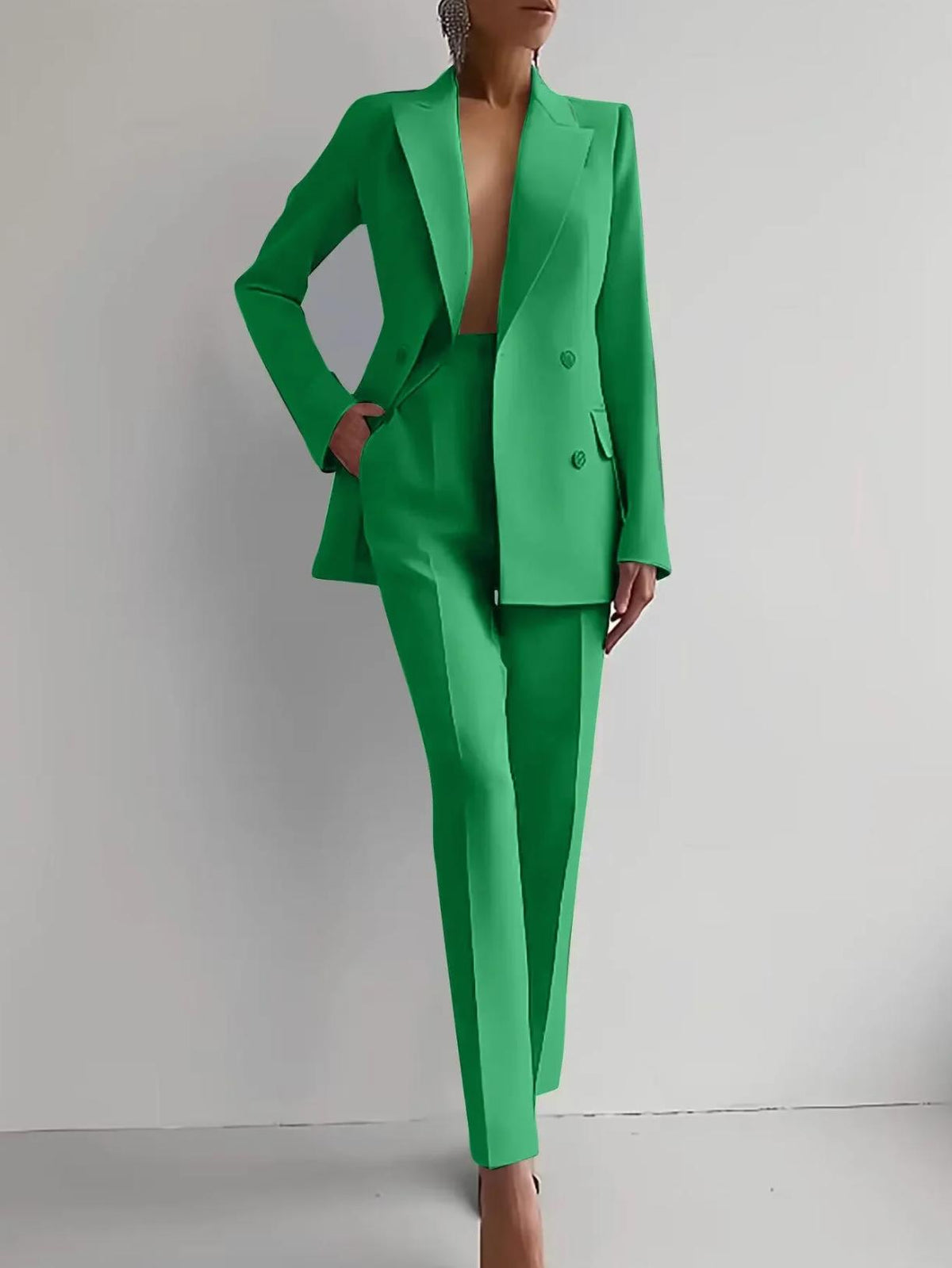 Woman wearing a vibrant green double-breasted satin two-piece suit with tailored ankle-length trousers.