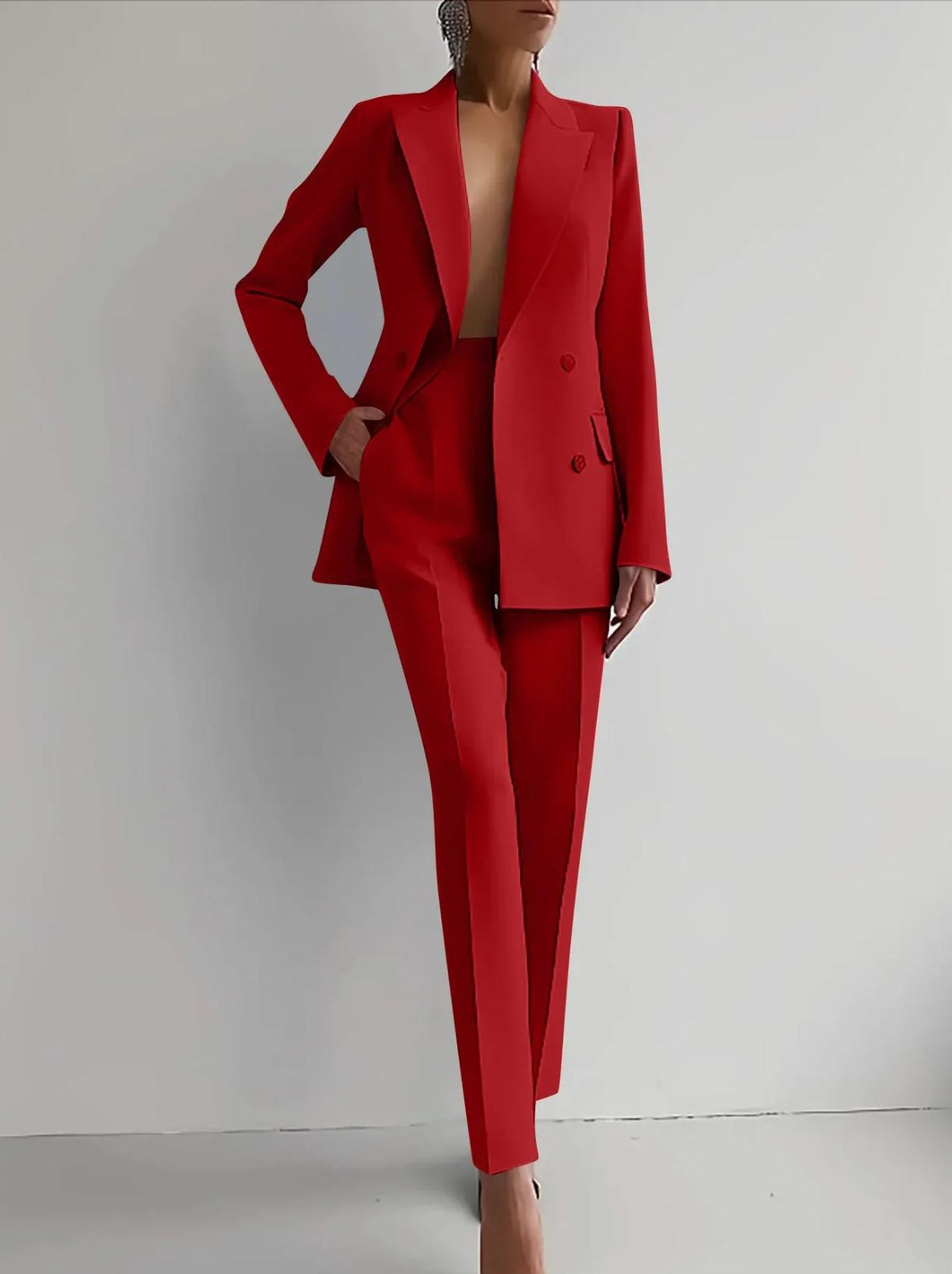 Woman wearing a bold red double-breasted Italian satin two-piece suit with tailored trousers and a structured blazer.