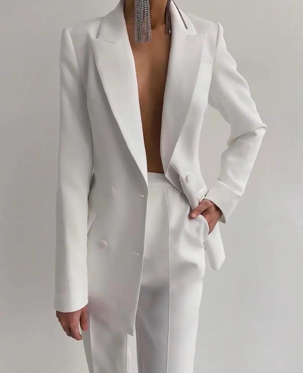 Tailored white double-breasted satin suit with structured blazer and matching trousers for a bold, elegant look.
