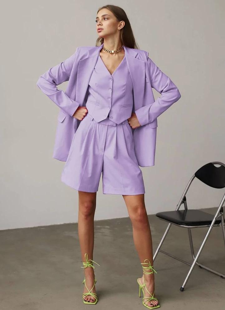 Lavender three-piece suit set featuring a loose blazer, buttoned vest, and tailored shorts on a model.