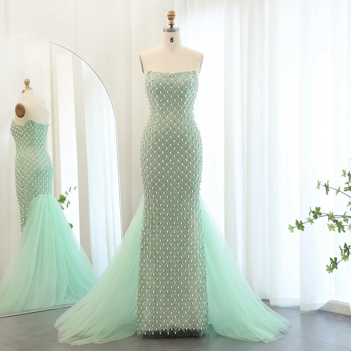 Sage green strapless mermaid gown featuring intricate pearl and crystal beading on tulle with a dramatic flared train.