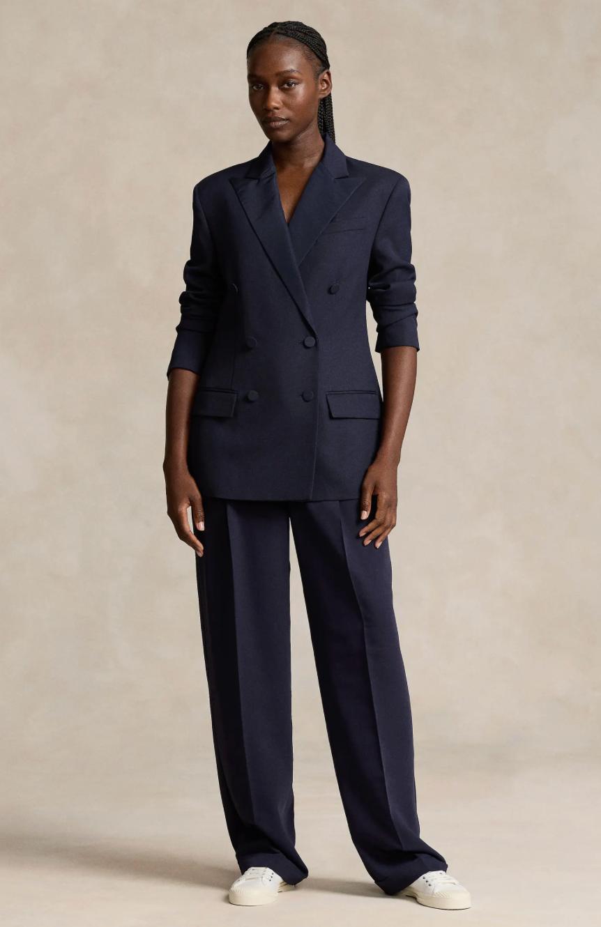 Model wearing a navy blue cotton twill double-breasted suit with a peak-lapel blazer and matching wide-leg trousers.
