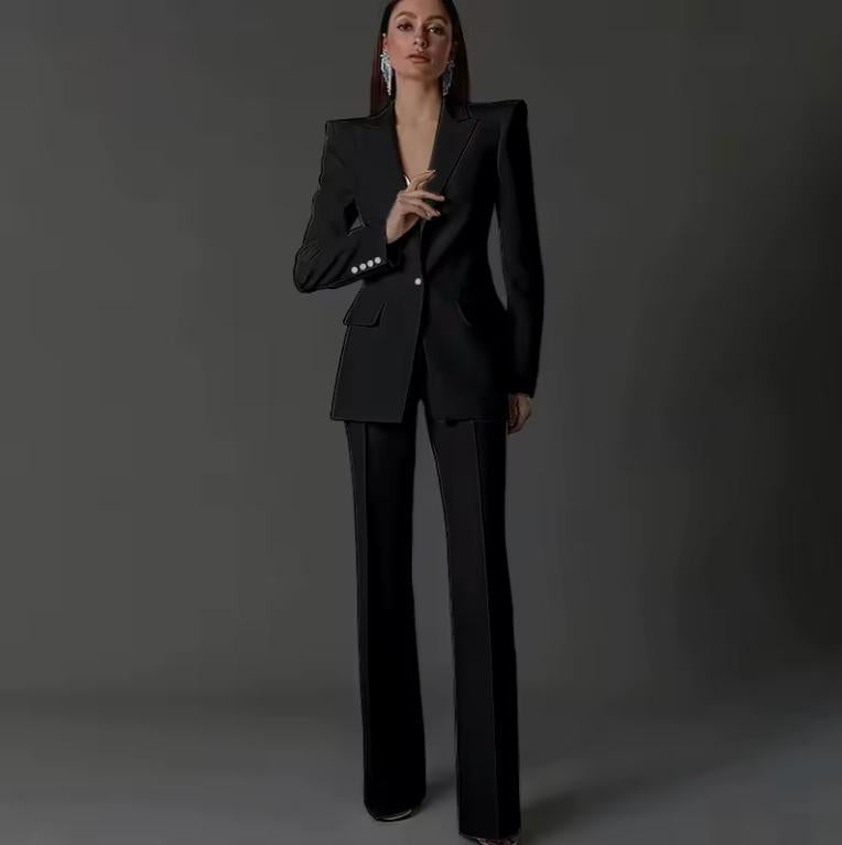 Woman wearing a sleek black Italian satin suit set with a sharp single-breasted blazer and tailored trousers.