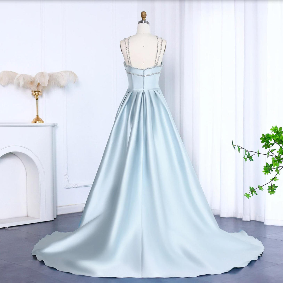 Light blue satin evening gown with crystal-beaded straps, a floor-length train, and a structured trumpet silhouette.