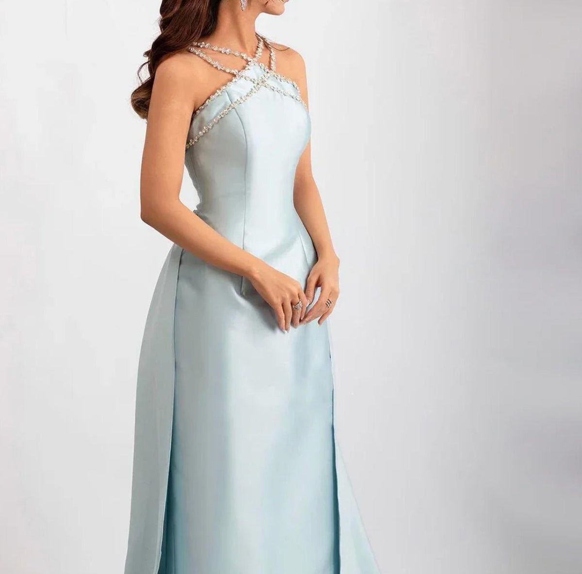 Light blue satin mermaid evening gown with a crystal-beaded halter neckline and an elegant overskirt.