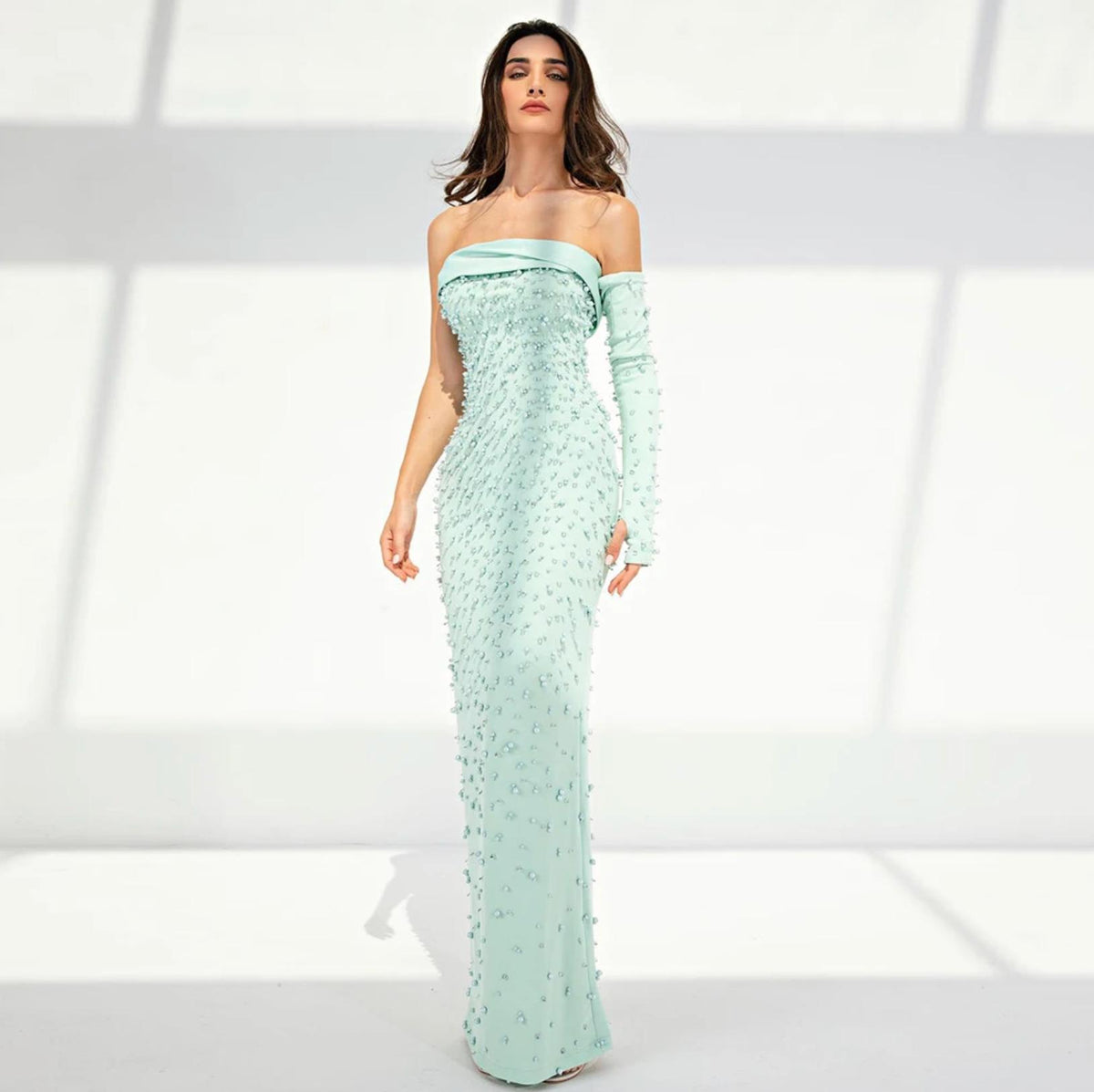 Mint sage green mermaid gown featuring Dubai pearl embellishments, a single sleeve, and a floor-length satin silhouette.