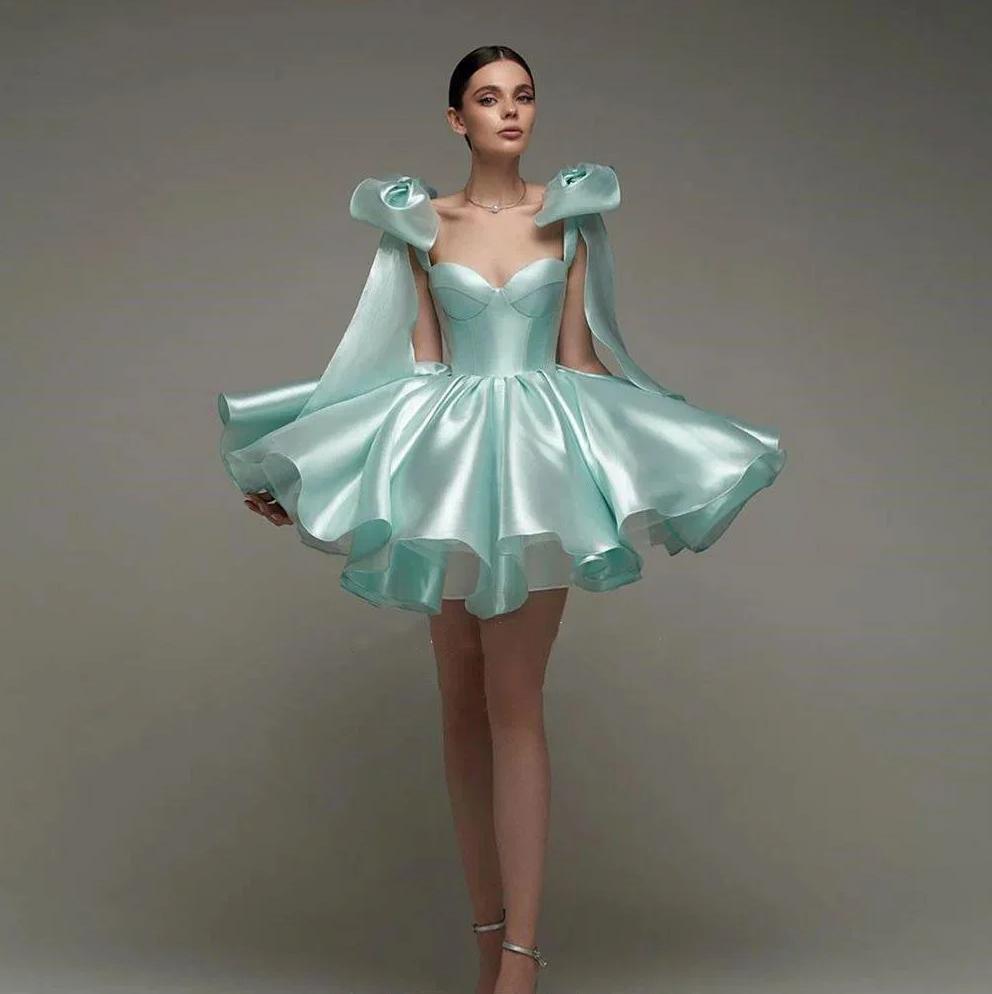 Mint green satin mini ball gown with sweetheart neckline, empire waist, and oversized bow shoulder straps.