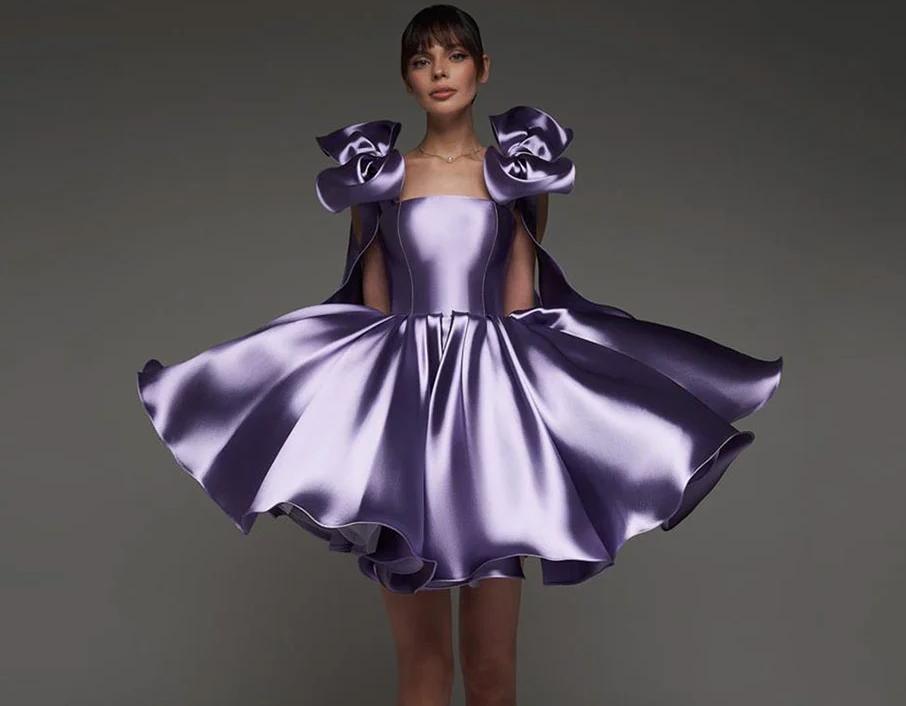 Purple satin mini ball gown with a sweetheart neckline, empire waist, and oversized shoulder bows.
