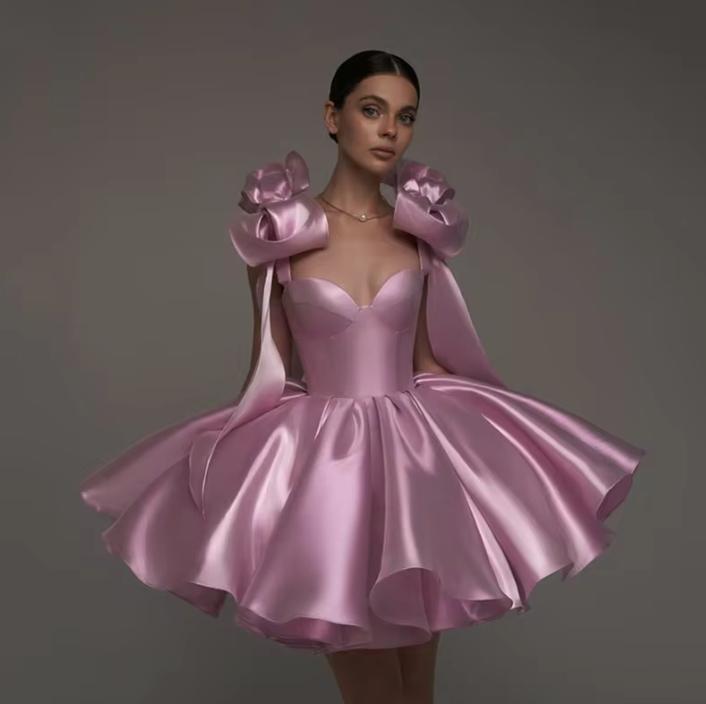 Pink satin mini ball gown with sweetheart neckline, empire waist, and oversized shoulder bows.