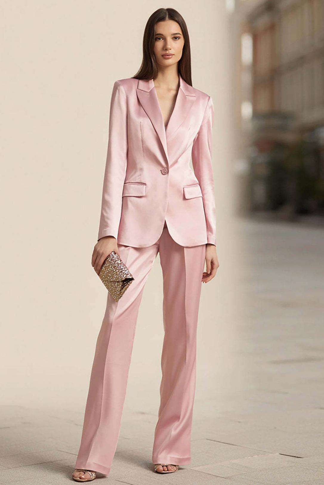Model wearing a slim-fit, light pink satin two-piece office suit with a peak lapel blazer and matching trousers.