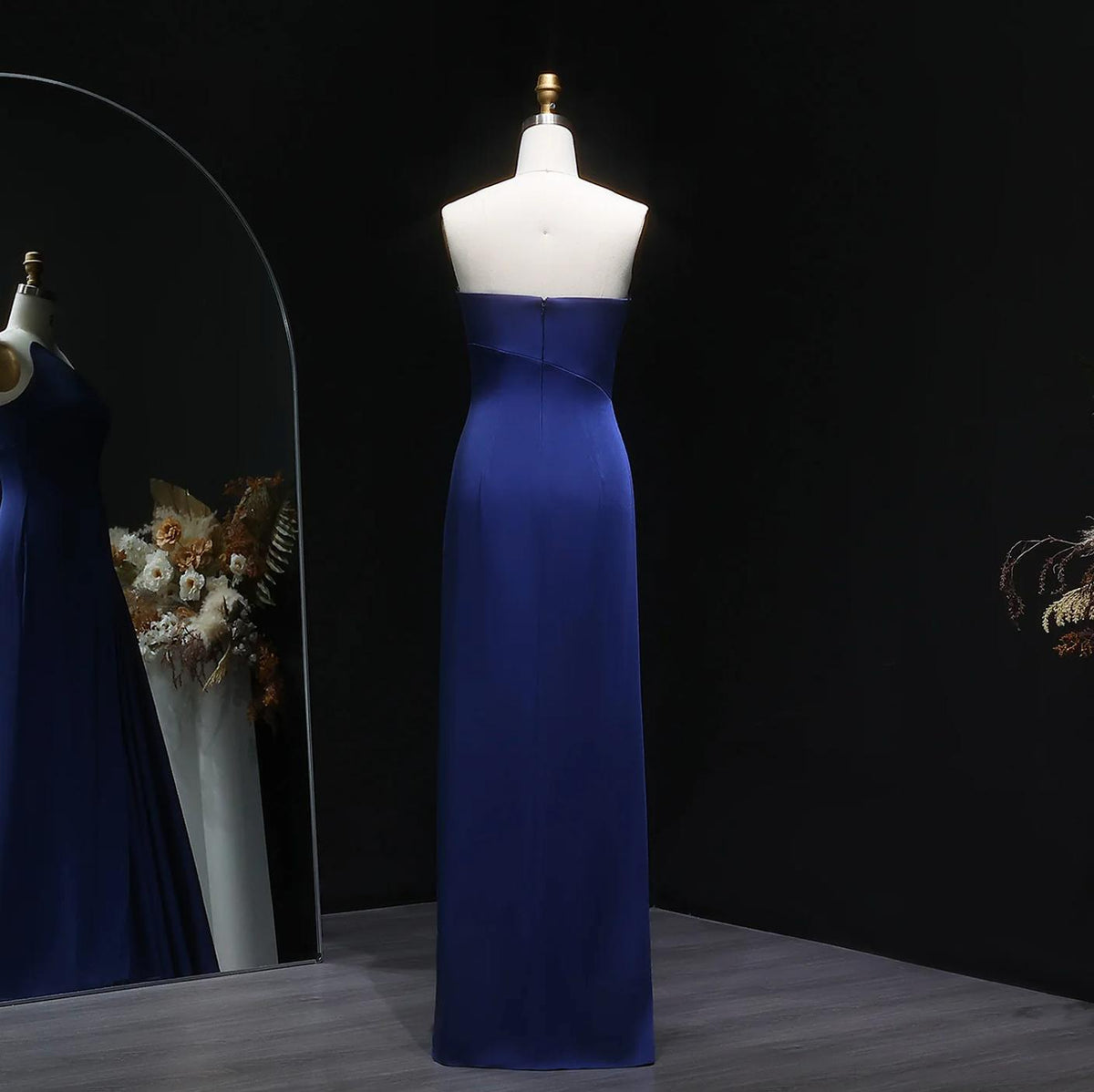 Dark blue floor-length taffeta mermaid gown with a strapless, sleeveless design on a mannequin.