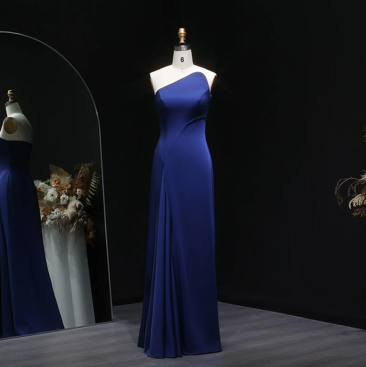 Elegant dark blue taffeta mermaid gown with a sleek one-shoulder design on a mannequin.
