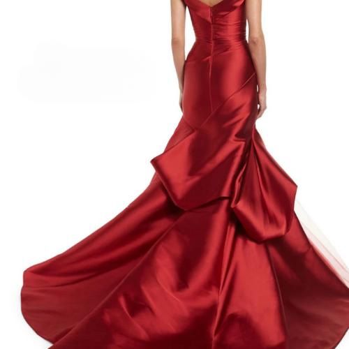 Red satin mermaid evening gown with an off-shoulder neckline, elegant back draping, and a dramatic floor-length train.